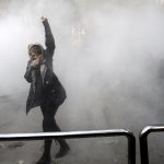 The protester that raises her arm as a symbol of resistance, while stepping out of teargas