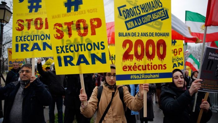 MEK supporters holding signs reading "Stop Executions Iran"