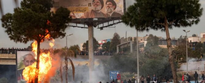 Clashes in the streets of Beirut. A billboard displays images of Hezbollah leader Hassan Nasrallah and Iran’s Supreme Leader Ali Khamenei